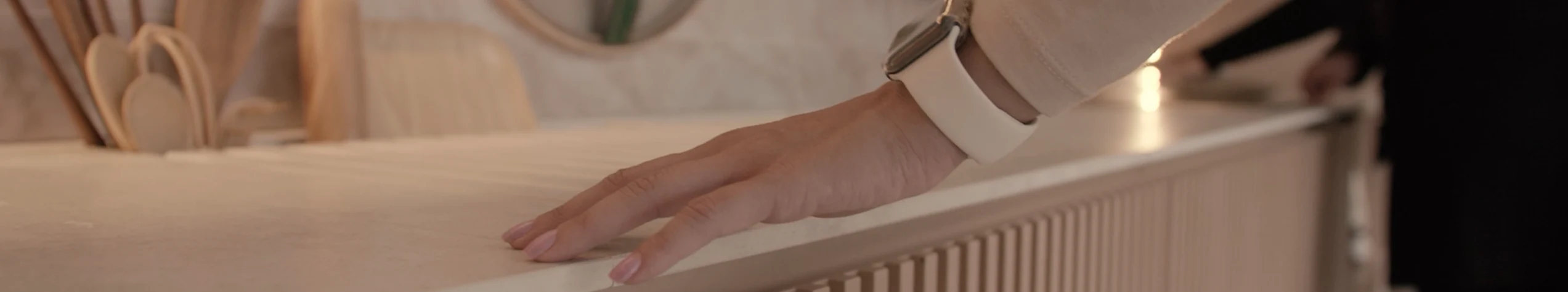 A visitor wearing an Apple Watch runs their hand over a wood countertop inside Casa Alma.